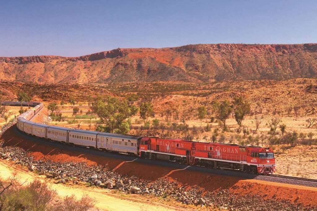 Australia landscape view of the Ghan train travelling through the sunny desert outback