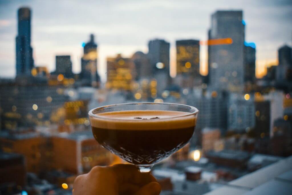 drink close up with city backdrop at dusk