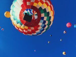 colourful hot air balloons flying above blue skies