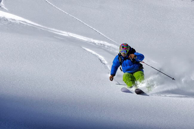 man skiing close up down slopes