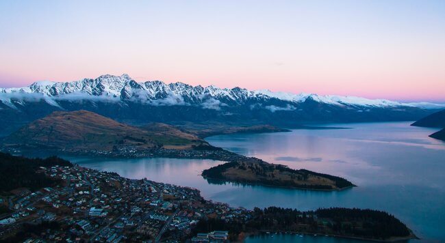 Queenstown view across lake and mountains pink sky