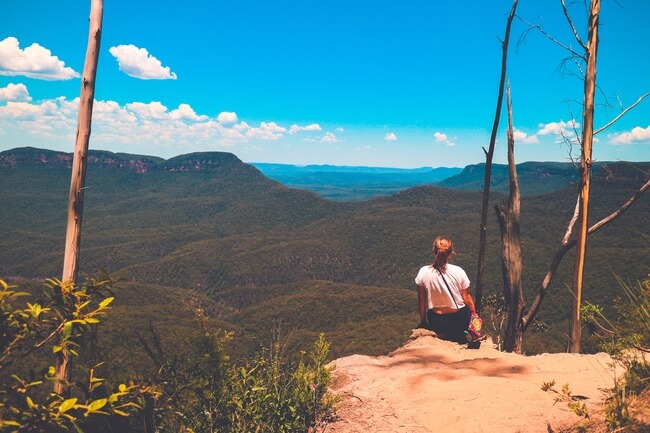 girl on rock edge over blue mountains Australia