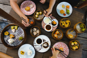 table people sharing steamed dumplings chopsticks