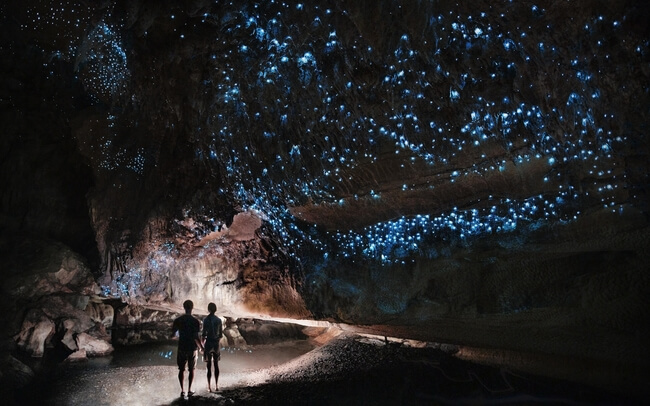 couple in dark cave glow worm sky New Zealand
