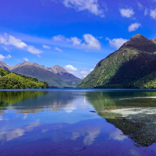 New Zealand Milford Sound cruise blue lake mountains tropical landscape
