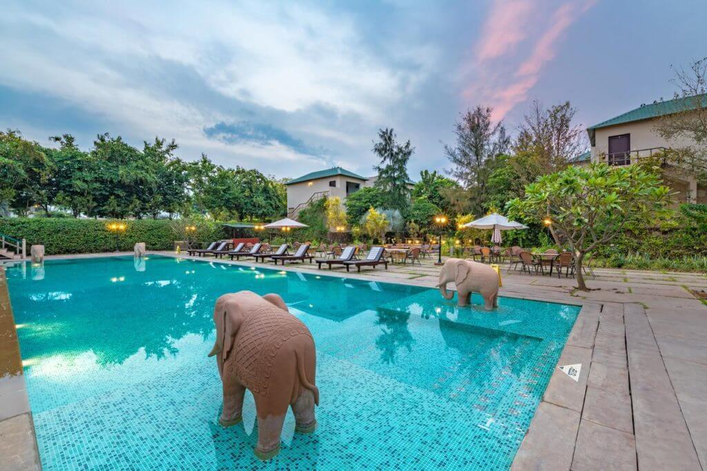 elephant statue in the pool of the Ranthambore Kothi hotel, with bungalows in background