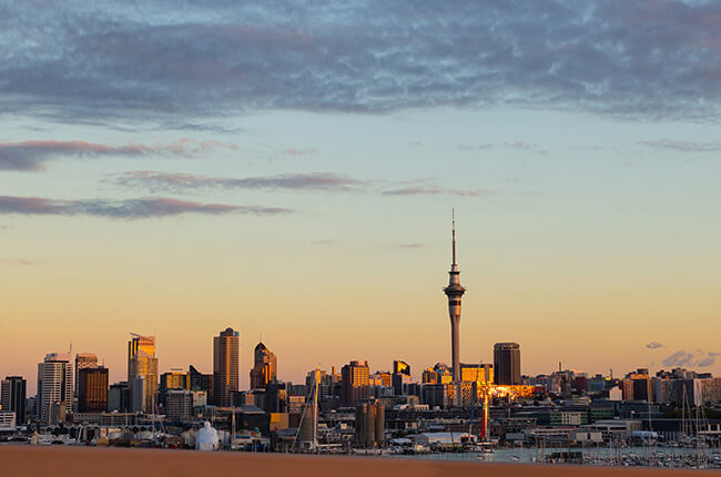 Auckland skyline in the far distance, with the Sky Tower reaching high into the sky at sunrise.