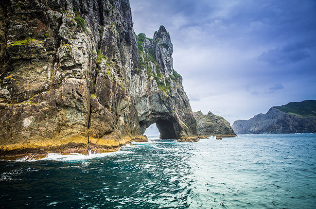 turquoise waters against the towering rocky formations with a hole running through the middle