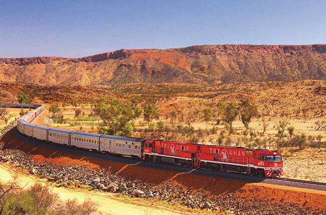 The Ghan train passing through the cobalt red land of the outback