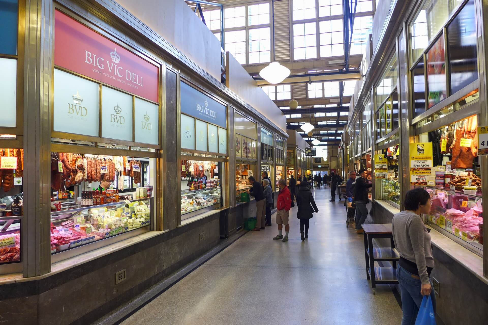Inside of the Melbourne Victoria Markets, with local deli counters and people shopping
