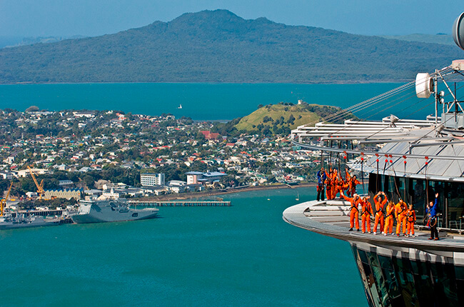 Sky tower with people in focus while blue seas and buildings scatter the background