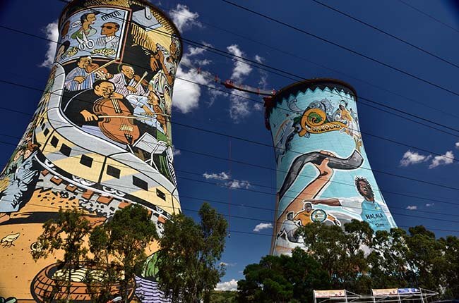 Famous Soweto towers covered in graffiti, with bungee jumper between the two towers