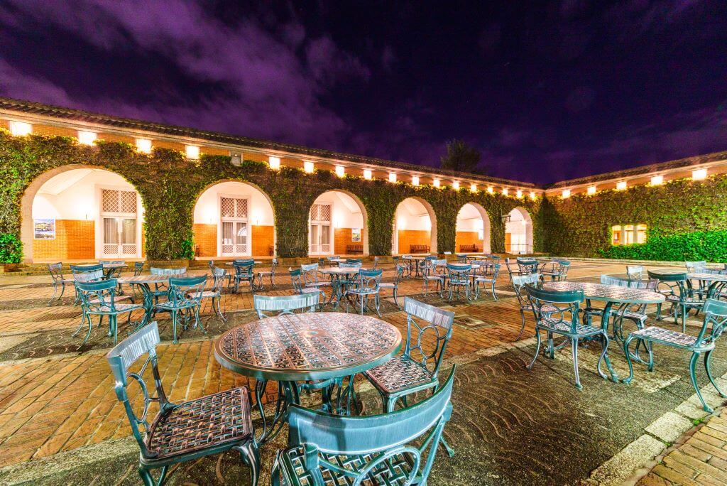 tables and chairs in courtyard at night