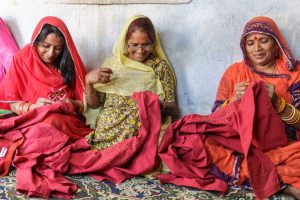 Women of Sadhna sewing and smiling