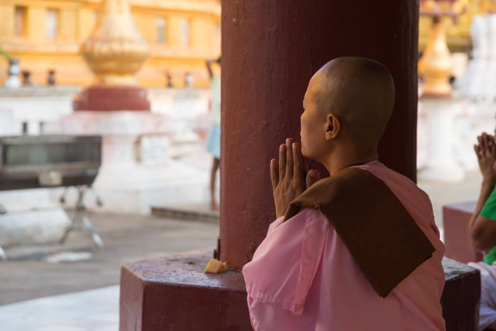 Female Buddhist praying in a temple in Kandy