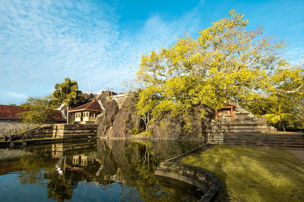 Mihintale & Isurumuniya Temple outside view with tree and pond in Habarana Sri Lanka