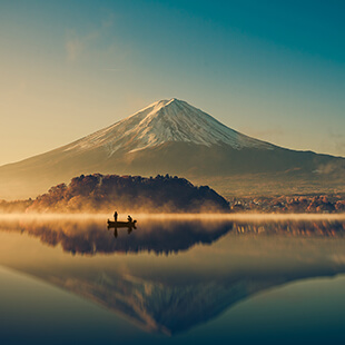 Mount Fuji at sunrise with boat on Lake Kawaguchiko