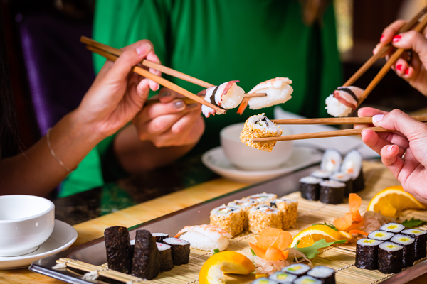 Chopsticks holding sushi and sashimi 