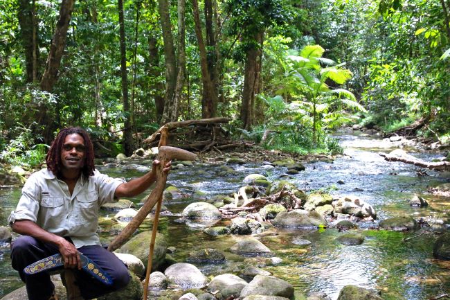 Cairns Daintree rainforest river with aboriginal guide holding walking stick and boomerang