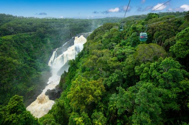 Kuranda skyrail cablecar travelling over rainforest passing waterfall