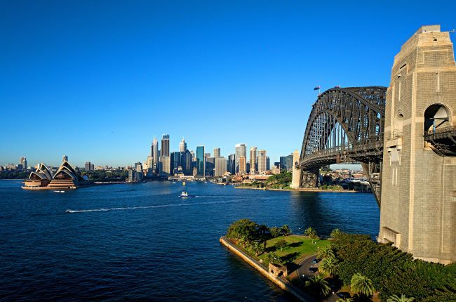 View of Sydney harbour with bridge to the side and front view of the Opera House