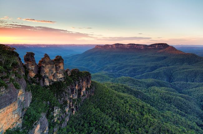 Three Sisters at the Blue Mountains, surrounded by green forest 