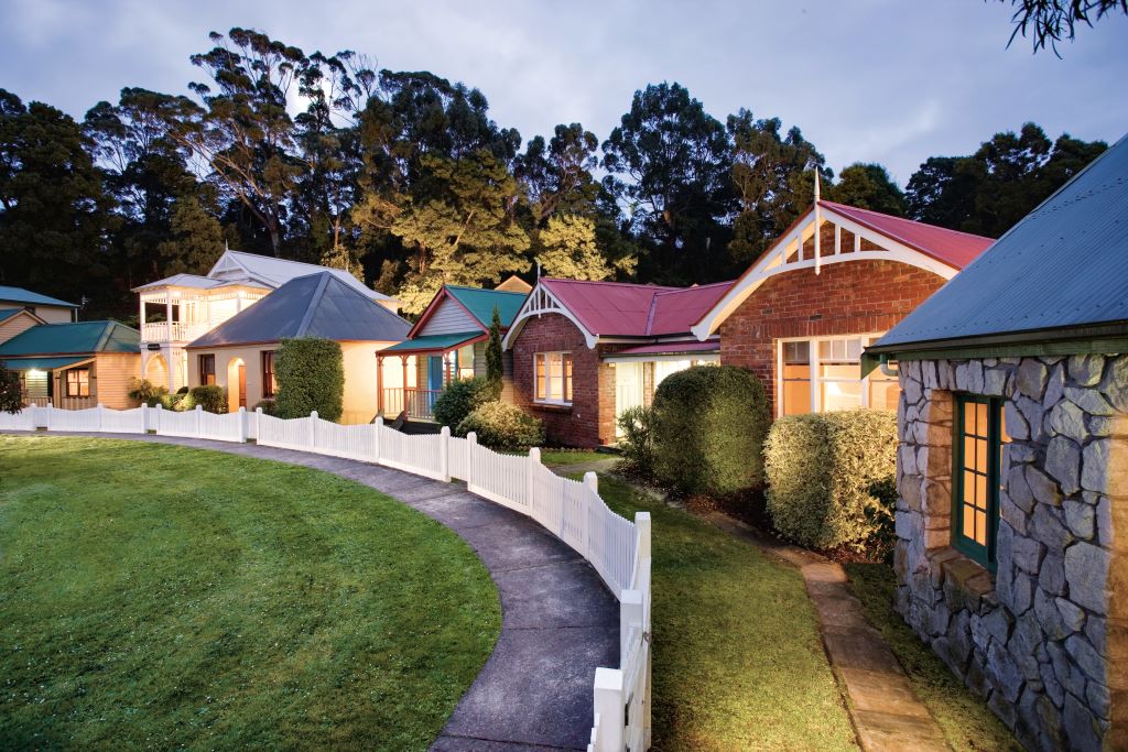 Strahan Village cottages with lights on at dusk