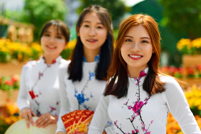 Three Vietnamese Girls Wearing Traditional Ao Dai Dresses in Ho Chi Minh City (Saigon) in Vietnam