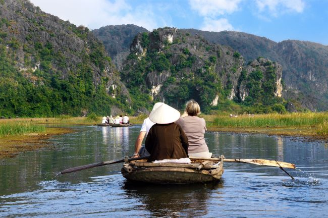 Tourists on the river viewing the towering limestone formations of Ninh Binh