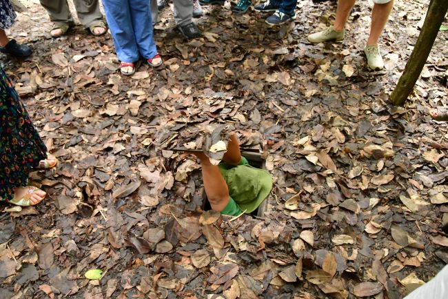 Guide appearing from an under ground Cu Chi tunnel, Vietnam