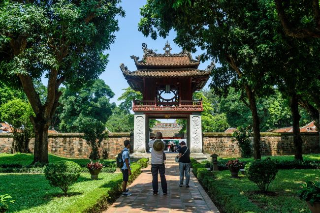 Couple taking a picture at the entrance to the Temple of Literature in Hanoi, Vietnam