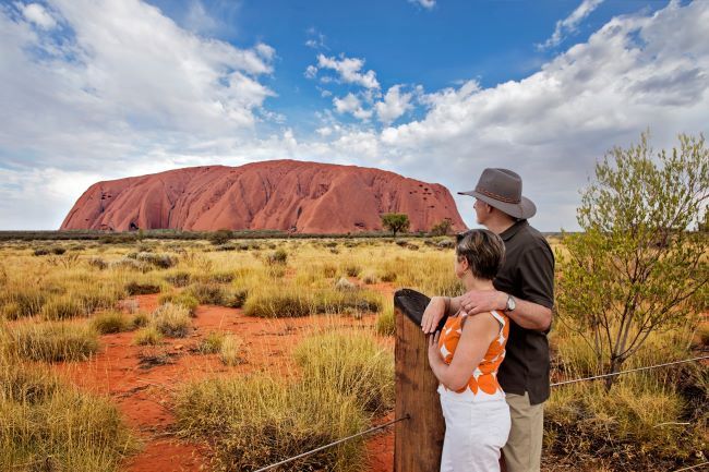Couple viewing the red rock of Uluru (Ayers Rock) at sunset