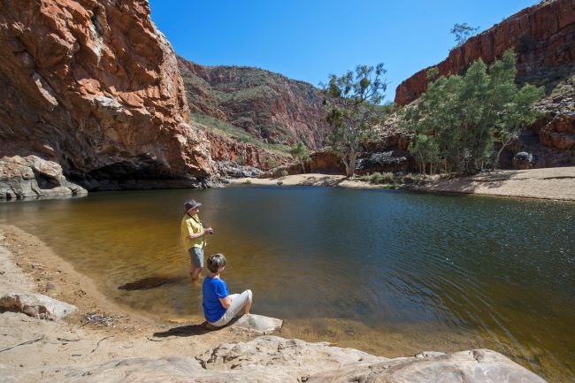 Couple enjoying the refreshing waters or Ormiston Gorge in Australia's Western MacDonnell Ranges