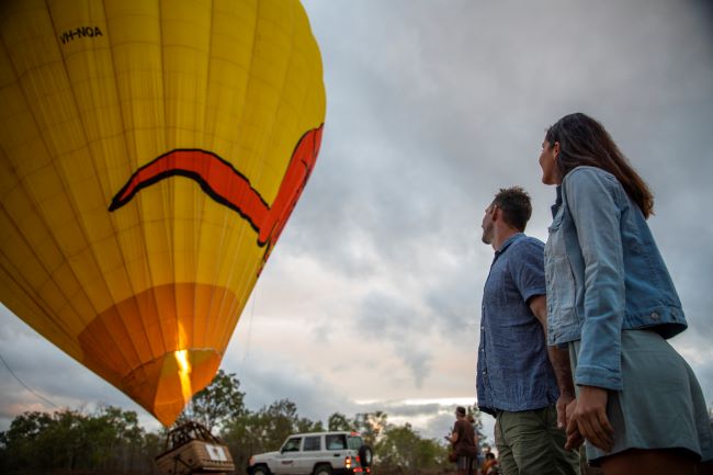 Couple looking towards a hot air balloon before take off