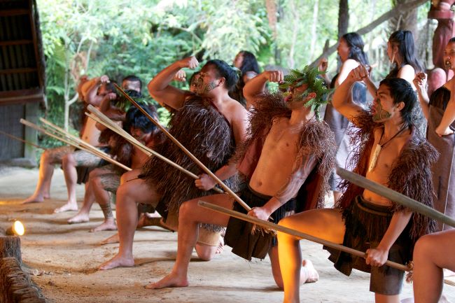 Maori men and women performing the famous war dance; the Haka