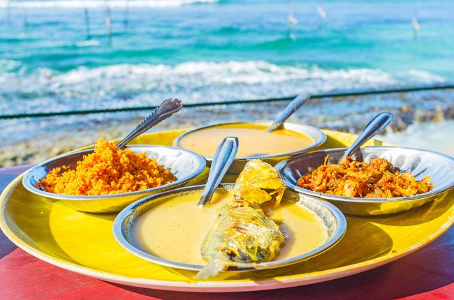 Selection of Sri Lankan food, with beach in the background