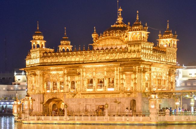 Golden Temple lit up against a dark night sky