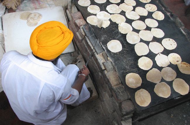 Indian man making Indian breads in the kitchens at the Golden Temple Amritsar