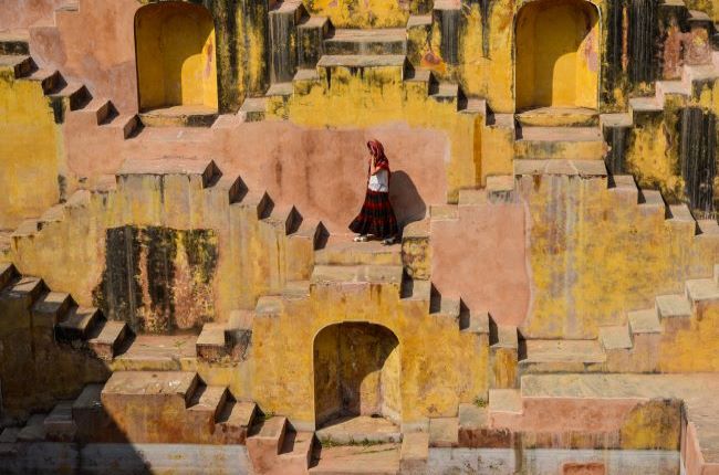 Indian lady on the steps on a sandstone stepwell in India