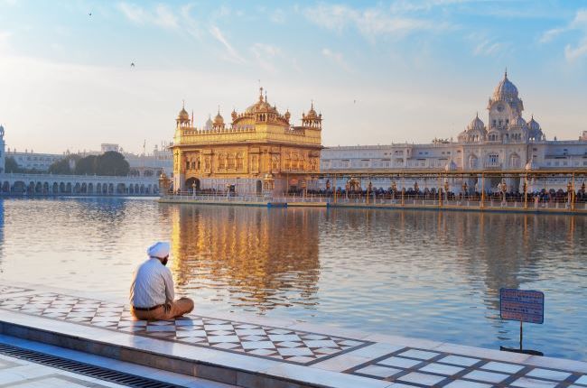 Indian man sat quietly in front of Golden Temple in Amritsar