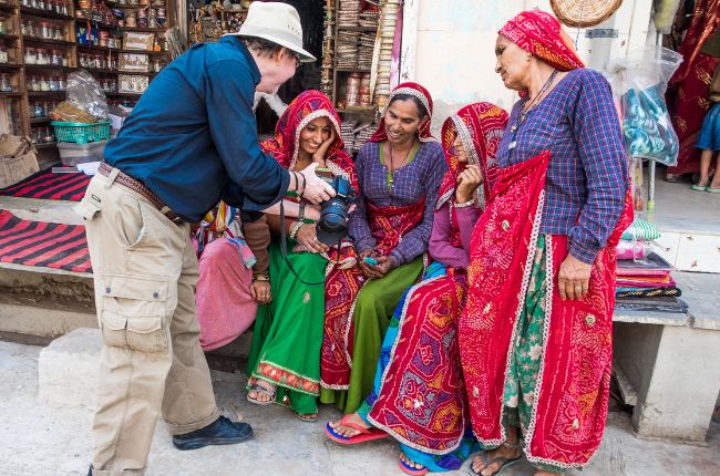 Tourist showing indian ladies an image on his camera