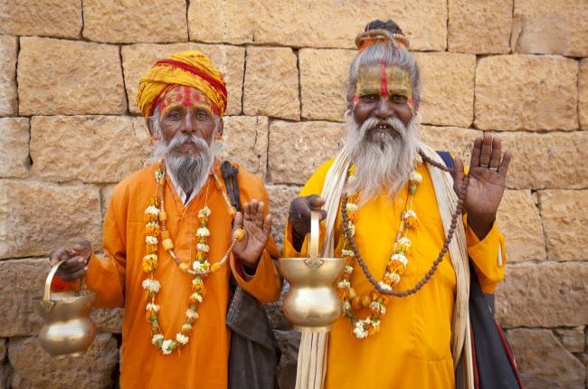 Two smiling, waving Jain Priests, India