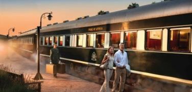 Couple walking by the side of the Pride of Africa train by Rovos Rail