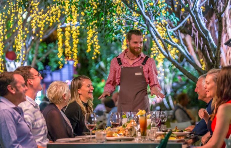 Waiter entertaining group of people dining