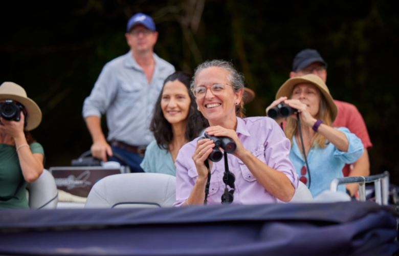 Group of tourists on boat with binoculars