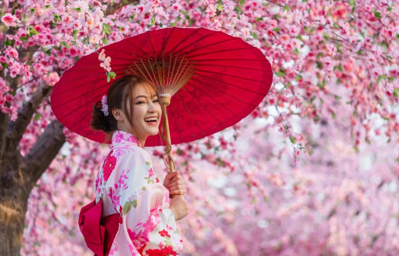 Smiling Japanese lady under cherry blossom