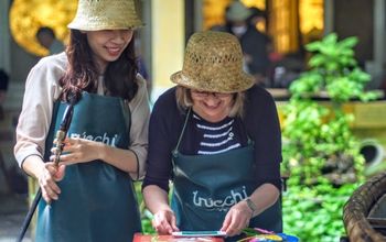 Lady with Vietnamese guide making Truc Chi paper art