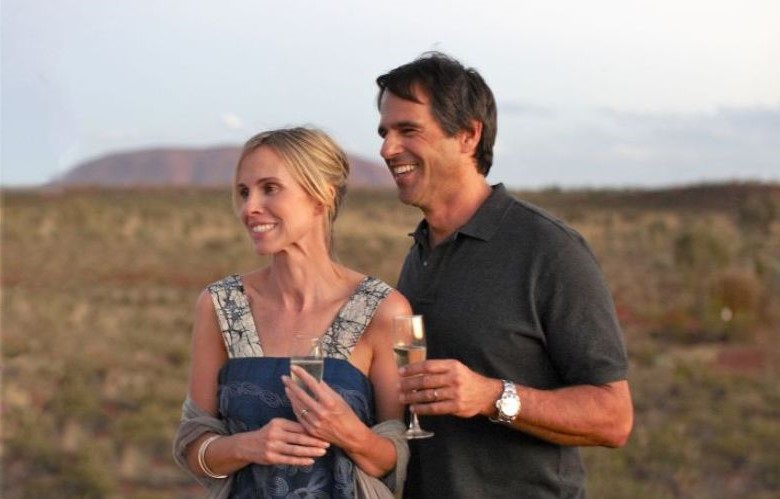 Couple drinking champagne with Uluru in the background